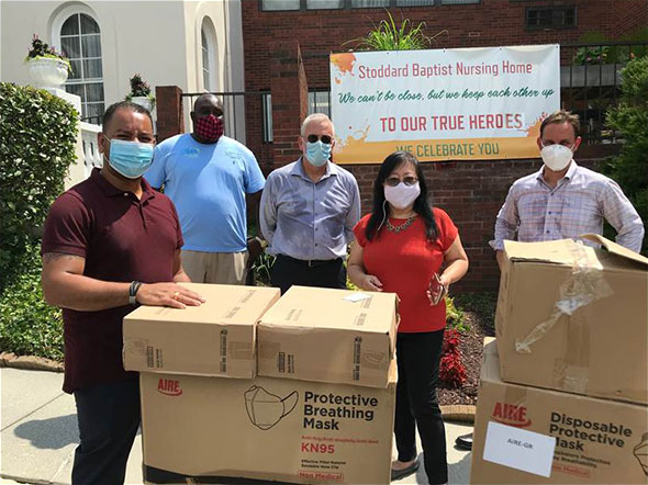group of people standing around boxes of PPE